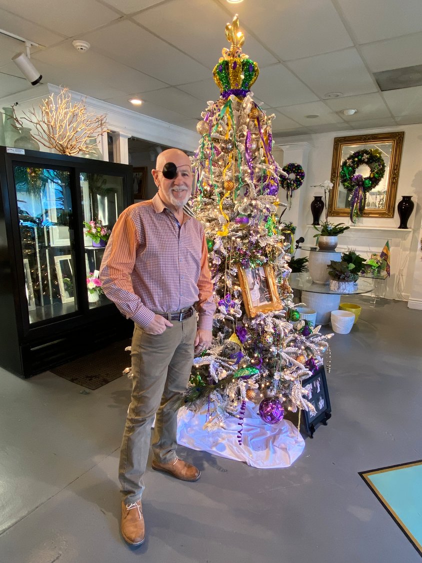 Carl Clark, AIFD, owner of Southern Veranda, keeps the Christmas tree in his shop lit through the Mardi Gras season and trades holiday red and green hues for purple, yellow and green decor.  Personal touches such as a framed photo of Clark and his daughter from their time as king and queen of the Mystic Stripers helped inspire the design.