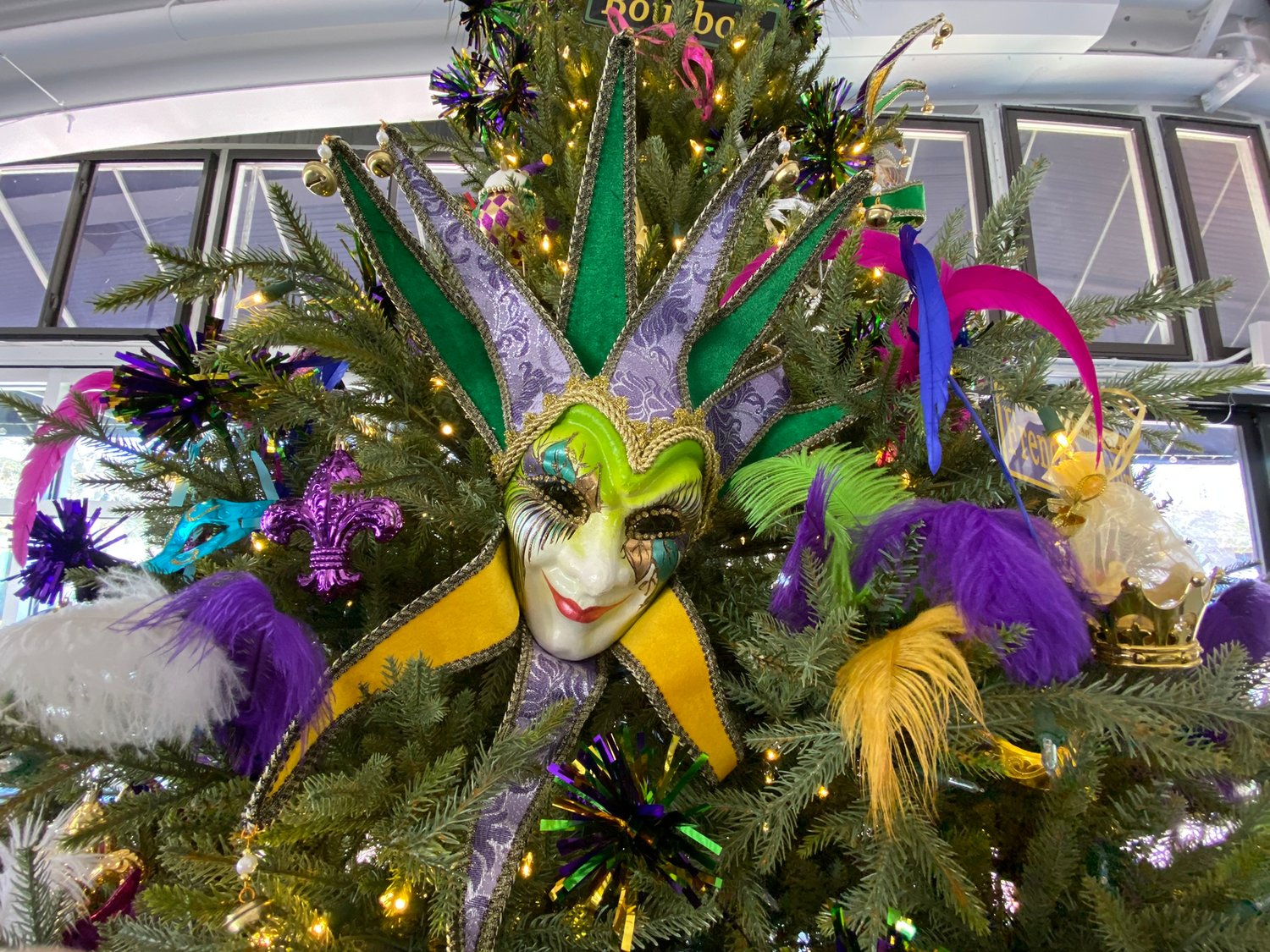 The massive tree inside The Mill, in Fairhope, is covered in Mardi Gras themed decorations including New Orleans street signs.