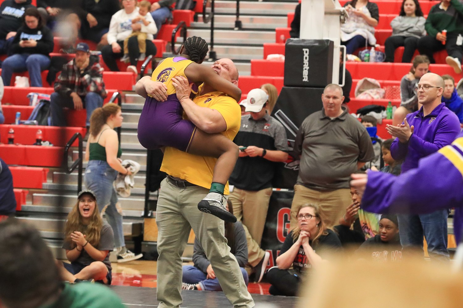 Daphne wrestler Kalyse Hill celebrates with coach Greg Jefcoat after winning the 134-pound state title on Saturday.