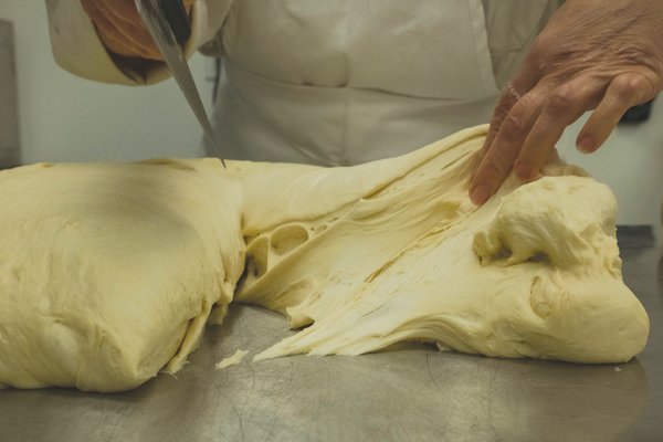 Chef Jule Roach separates bread dough for king cakes in the bakery at Fairhope Chocolate.