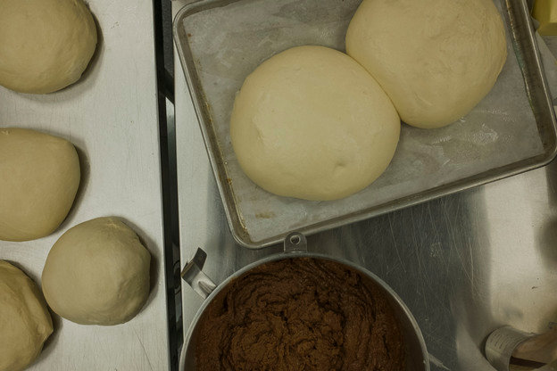 Eight hundred gram balls of dough sit ready to be turned into king cakes at Fairhope Chocolate.