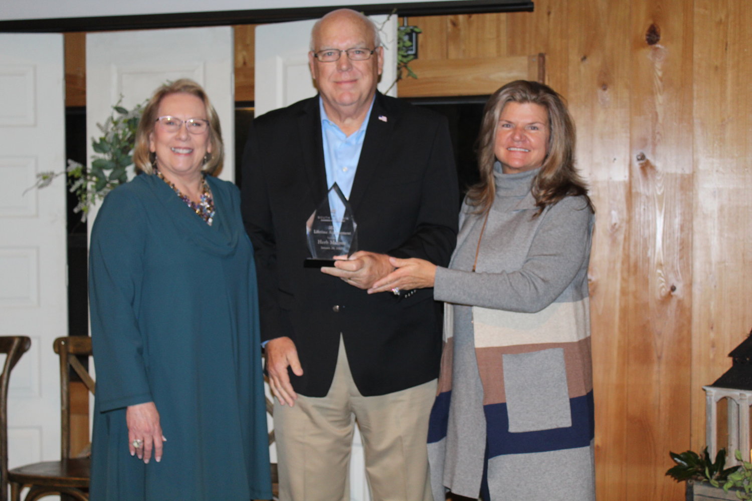 Donna Watts and Charlene Haber present the Lifetime Achievement Award to Herb Malone, recently retired director of Gulf Shores Orange Beach Tourism.