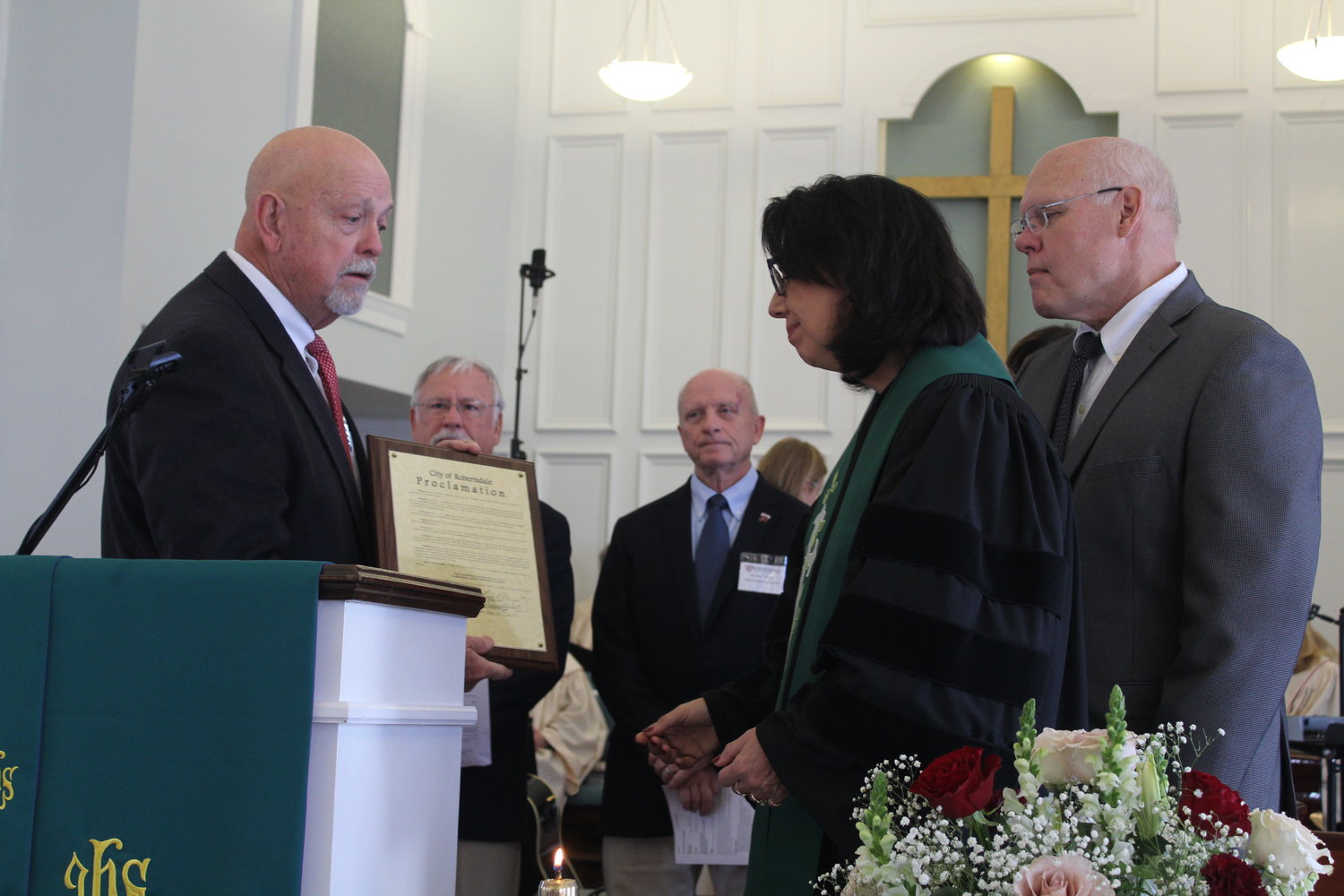Mayor Charles Murphy presents a proclamation from the city to the Rev. Dr. Christine Cook.
