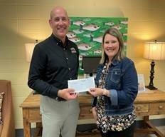 Greg Shoemaker, executive administrator of Baldwin Bone & Joint, presents the first-place award check to school counselor Beth Ann Mills of Fairhope East Elementary School.