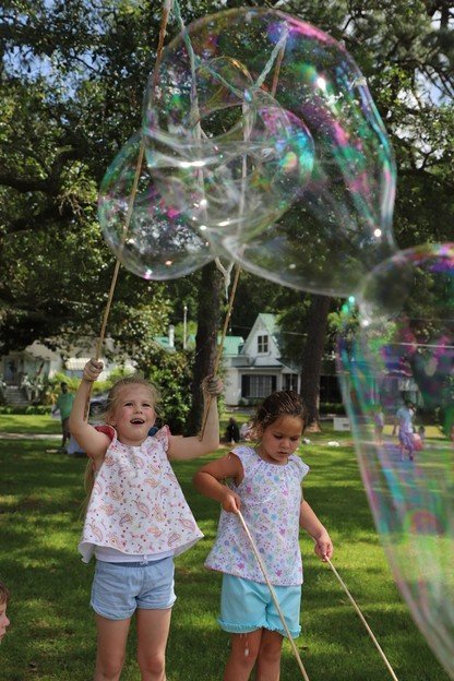 Children play with giant bubbles during the Chalk the Trail event Saturday in Fairhope.