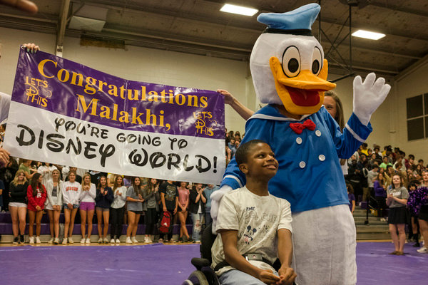Malakhi Washington poses for a photo with Donald Duck at the Daphne High School on Friday after Washington was surprised with a free trip to Disney World through Magic Moments, an Alabama-based company that provides children diagnosed with chronic, life-threatening illnesses with opportunities to live out their dreams.
