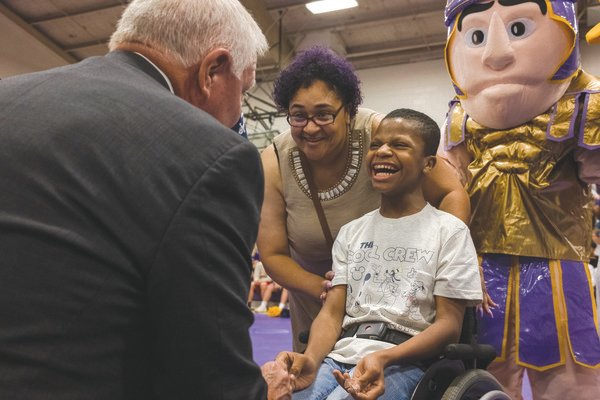 Tiffaney Baker and her son Malakhi Washington speak to Baldwin County Superintendent Eddie Tyler at Daphne High School on Friday after Washington was surprised with a free trip to Disney World through Magic Moments, an Alabama-based company that provides children diagnosed with chronic, life-threatening illnesses with opportunities to live out their dreams.