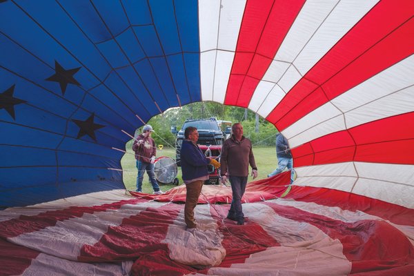 Gary Brossett, a hot air ballon pilot and crew member, and Rusty Miller check the interior of “Stars & Stripes”, Miller’s balloon, before a flight outside of Atmore last week.