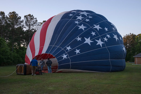 Gary Brossett (right), a hot air ballon pilot and crew member, and Rusty Miller do pre-flight checks on “Stars & Stripes”, Miller’s balloon, before a flight outside of Atmore last week.