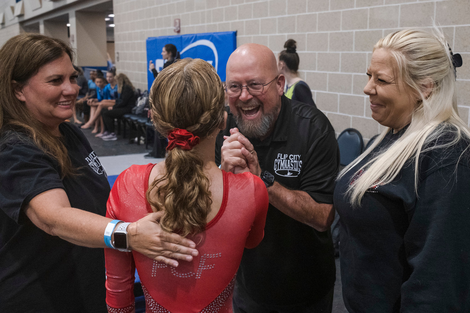 Flip City Academy gymnasts Saoirse McDaniel, 14, of Daphne celebrates with her coaches.
