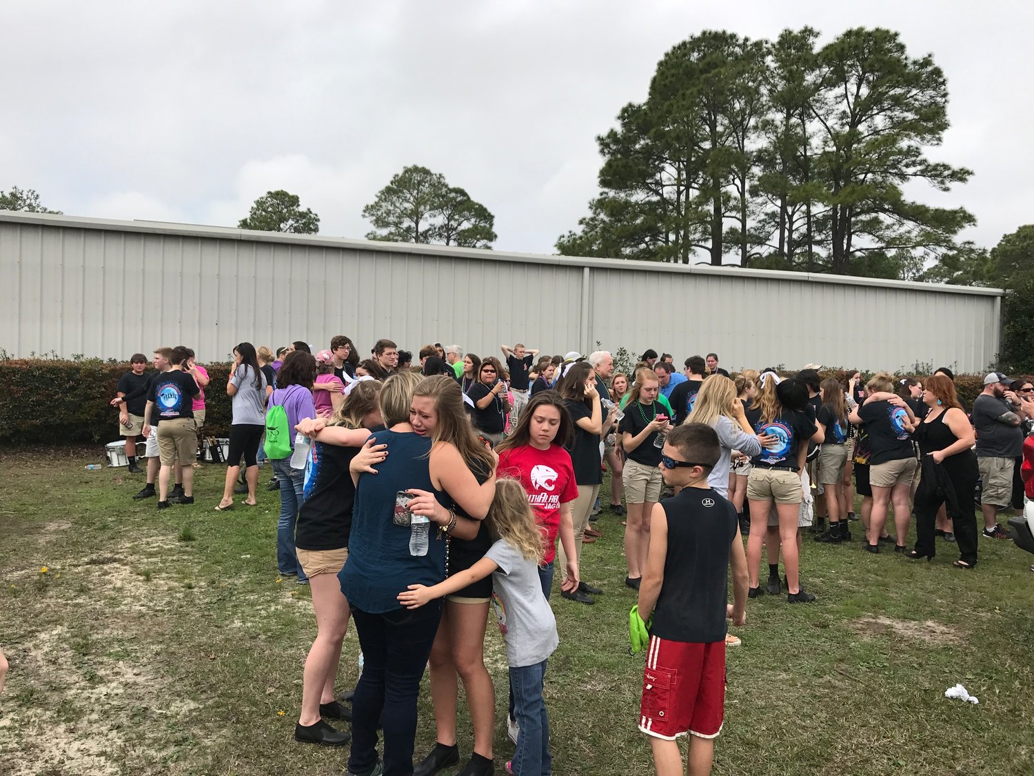Students in the Gulf Shores High School Band console one another after a car accident in the city's 2017 Mardi Gras Parade injured twelve of the band's members.
