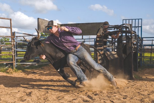 Drew Clukey runs with a steer out of the chute during practice at Luke Campbell’s farm.