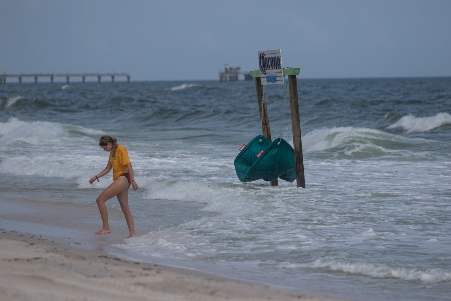 A festival goer walks out of the beach on Friday, May 20. Beach access points were closed early Saturday due to rough wave conditions.
