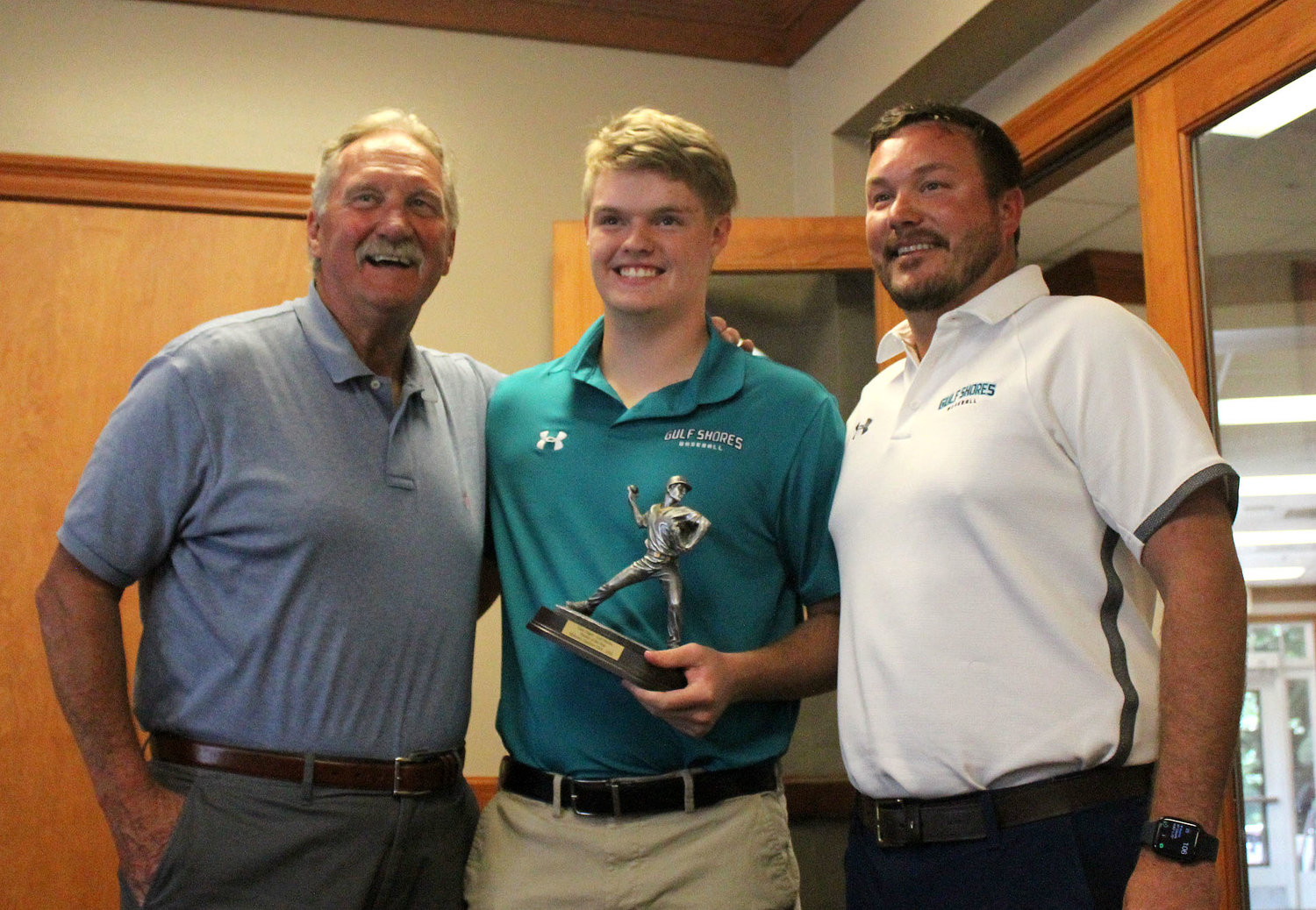 Gulf Shores’ Case Hager was named the Midtown Optimist Club Baldwin County Pitcher of the Year. He was presented the trophy by guest speaker and Mobile Sports Hall of Famer Randy McGilberry at the Azalea City Golf Club May 25. He was joined by Dolphin Head Coach Chris Jacks.