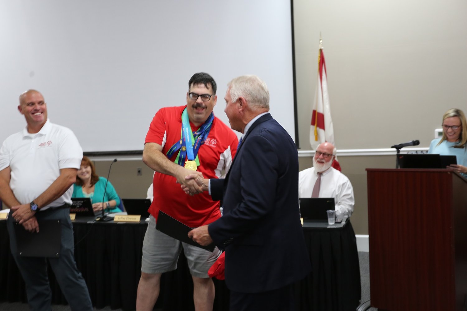 Powerlifter Jerry Wise greets Baldwin County Superintendent Eddie Tyler during Baldwin County Board of Education’s June 23 meeting. Wise was recognized for his performance at the USA Games in Orlando earlier this month.