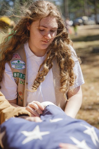 Girl Scout Ambassador Rachel Marlow folds a flag during a flag retirement ceremony earlier this year. The 2022 Fairhope High School graduate earned her Girl Scout Gold Award this year by creating donation boxes where the community could bring worn flags to be properly retired.