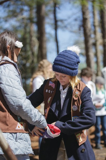 Members of Girl Scout Troop 8017, of Fairhope, learned to properly retire U.S. flags as part of Ambassador Girl Scout Rachel Marlow’s Gold Award project. They retired dozens of flags earlier this year during a weekend camp out. Here Peyton O’Bannon and Ida Mae Myrick, both of Fairhope, learn to fold a flag.