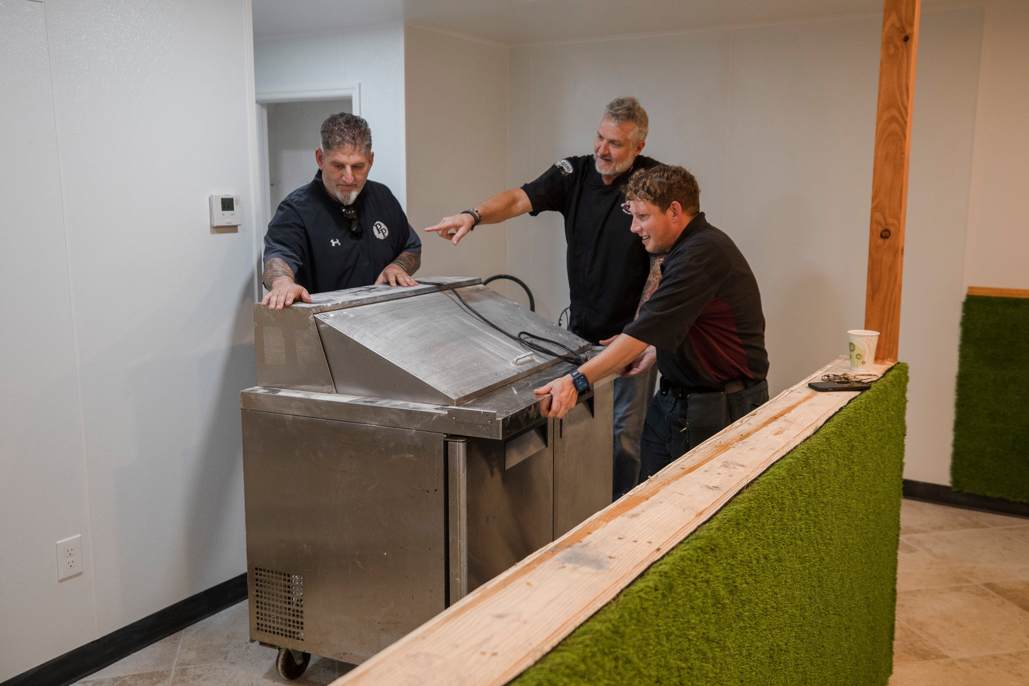 (From left) Nick Dimario, Pete Blohme and Johnny Stewart work inside the future Fairhope Squeeze Juice Bar and Fruiteria.