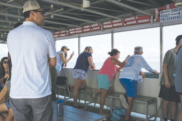 Visitors aboard Blakeley State Park's Delta Explorer lean out for a closer look at Middle Bay Lighthouse last week during a three-hour cruise offered by the park.