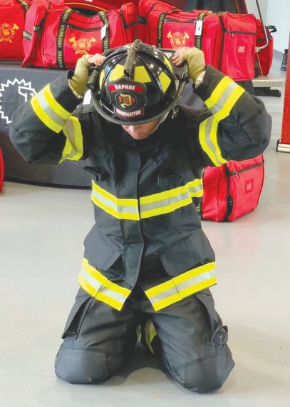 A Daphne firefighter puts on fire turnout gear. The city bought $280,000 in new protective equipment.