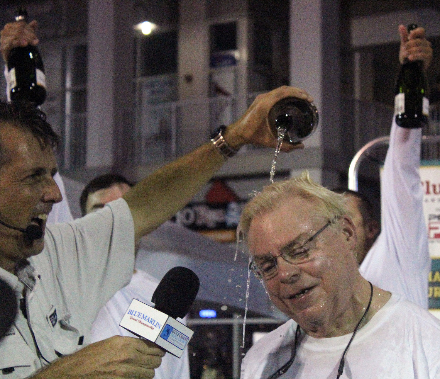 Blue Marlin Grand Championship host Jim Cox shares his champagne with A Work Of Art Owner Art Favre after his boat won the Gulf Coast Triple Crown at The Wharf last Saturday night, July 23.