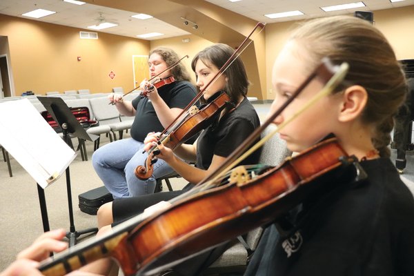 Juliana White of Foley, Diane Matier of Silverhill and William Morris of Elberta practice before a performance last week at the end of summer camp with the Baldwin County Youth Orchestra.