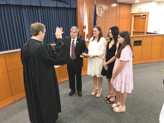 Baldwin County Commissioner Matt McKenzie takes the oath of office from Circuit Court Judge Jody Bishop on Tuesday, Aug. 2. McKenzie will complete the term of retired Commissioner Joe Davis before starting the term for which he was elected in November.