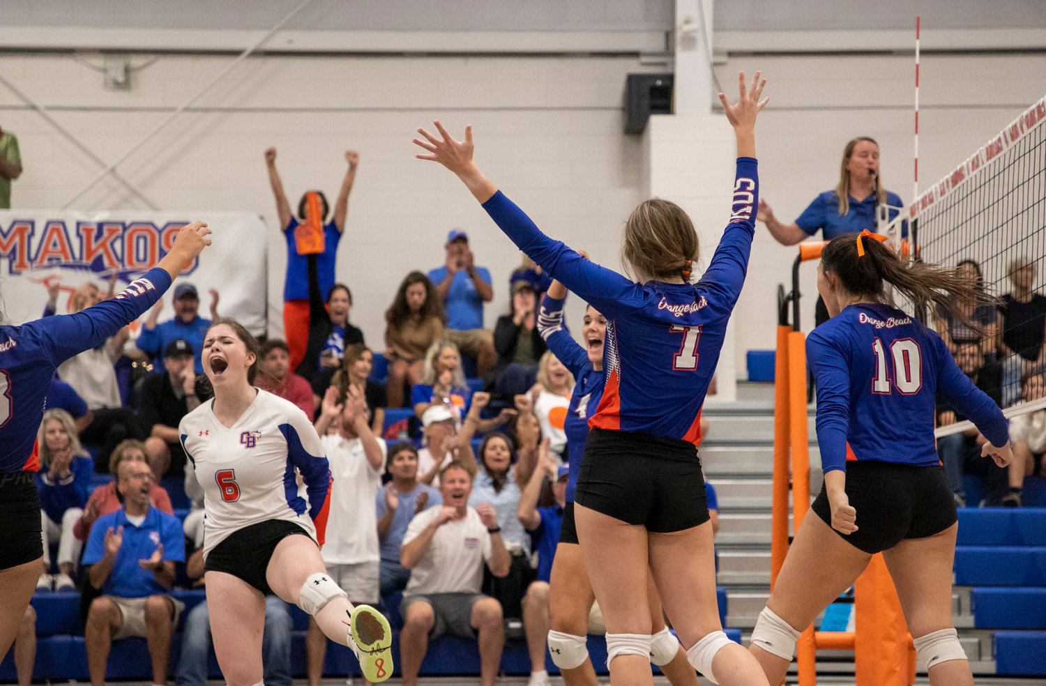 Leyni Young (6) and the Orange Beach Makos celebrate a point during their tri-match against the Gulf Shores Dolphins Thursday night at home.