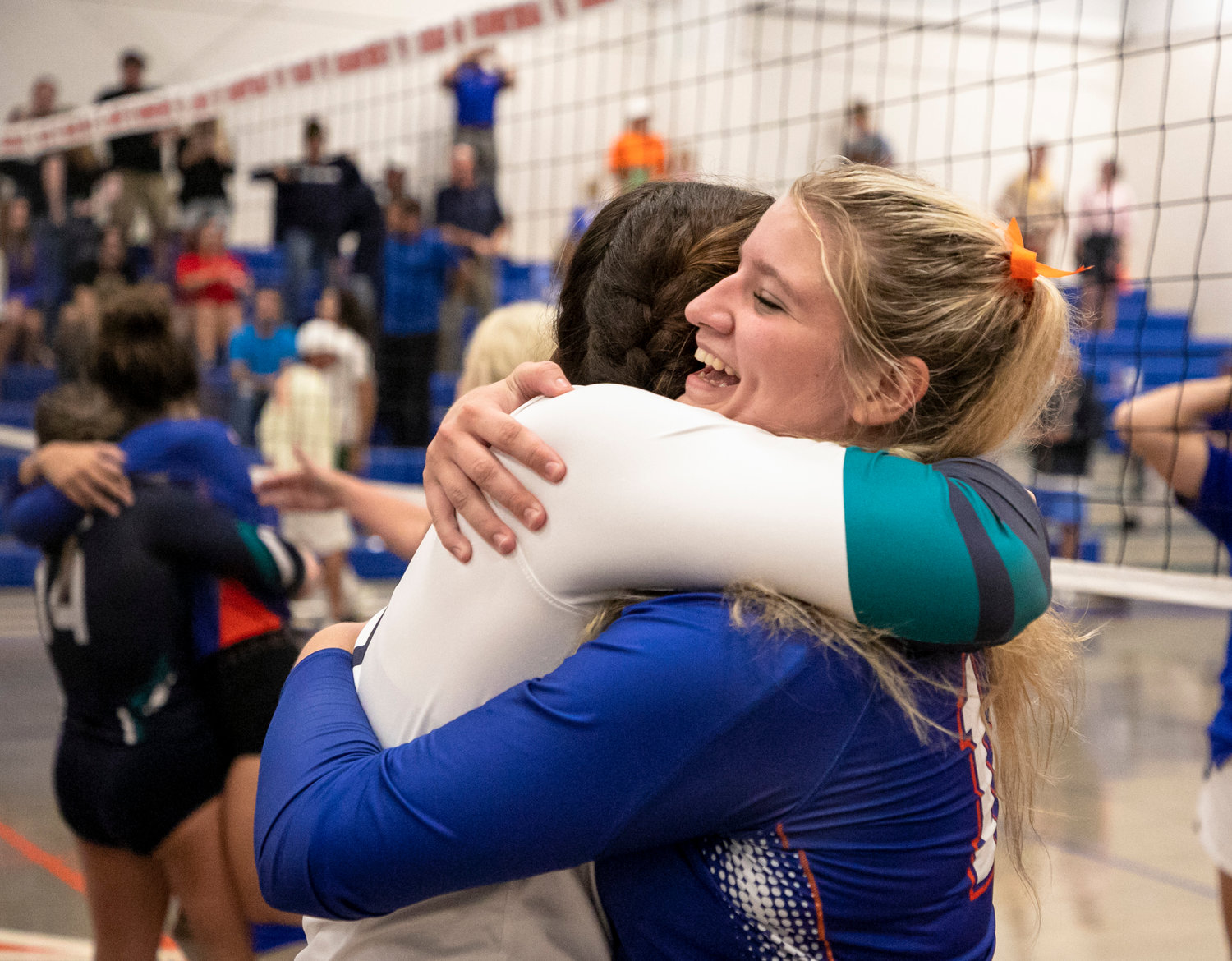 Despite wearing rival high school colors, many Orange Beach Makos and Gulf Shores Dolphins share bonds on the club volleyball level and embraced after the tri-match in The Cage at Orange Beach High School Thursday night, Aug. 25.