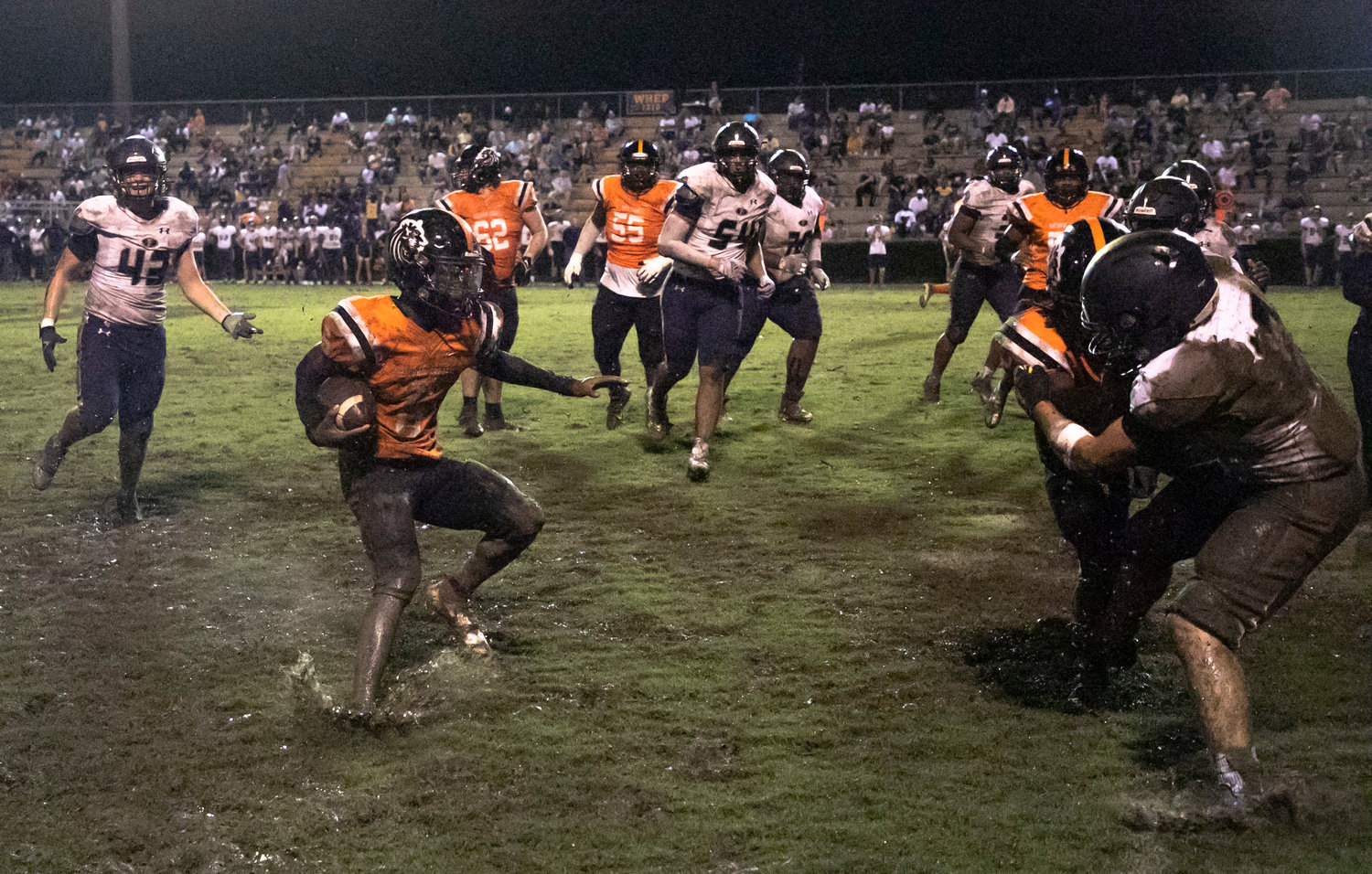 Tiger receiver Damorien Andrews looks for running room while traversing the muddy gridiron on Mitchell Field at Lyle Underwood Stadium in Bay Minette Friday night.
