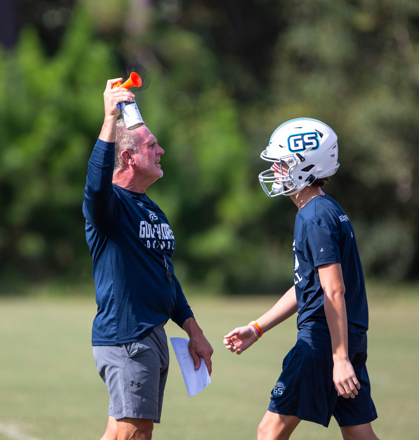 Gulf Shores head coach Mark Hudspeth uses an airhorn to move Thursday’s walkthrough to the next period. The Dolphins are set to tango with the top-ranked team in 5A, UMS-Wright Prep, Friday night.