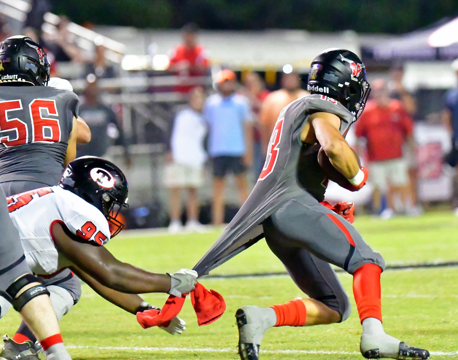 Spanish Fort running back Sawyer Wilson looks for running room while Theodore defensive lineman Jordan Bolden tugs on his jersey during the region game between the Toros and Bobcats Friday night, Sept. 16, in Spanish Fort.