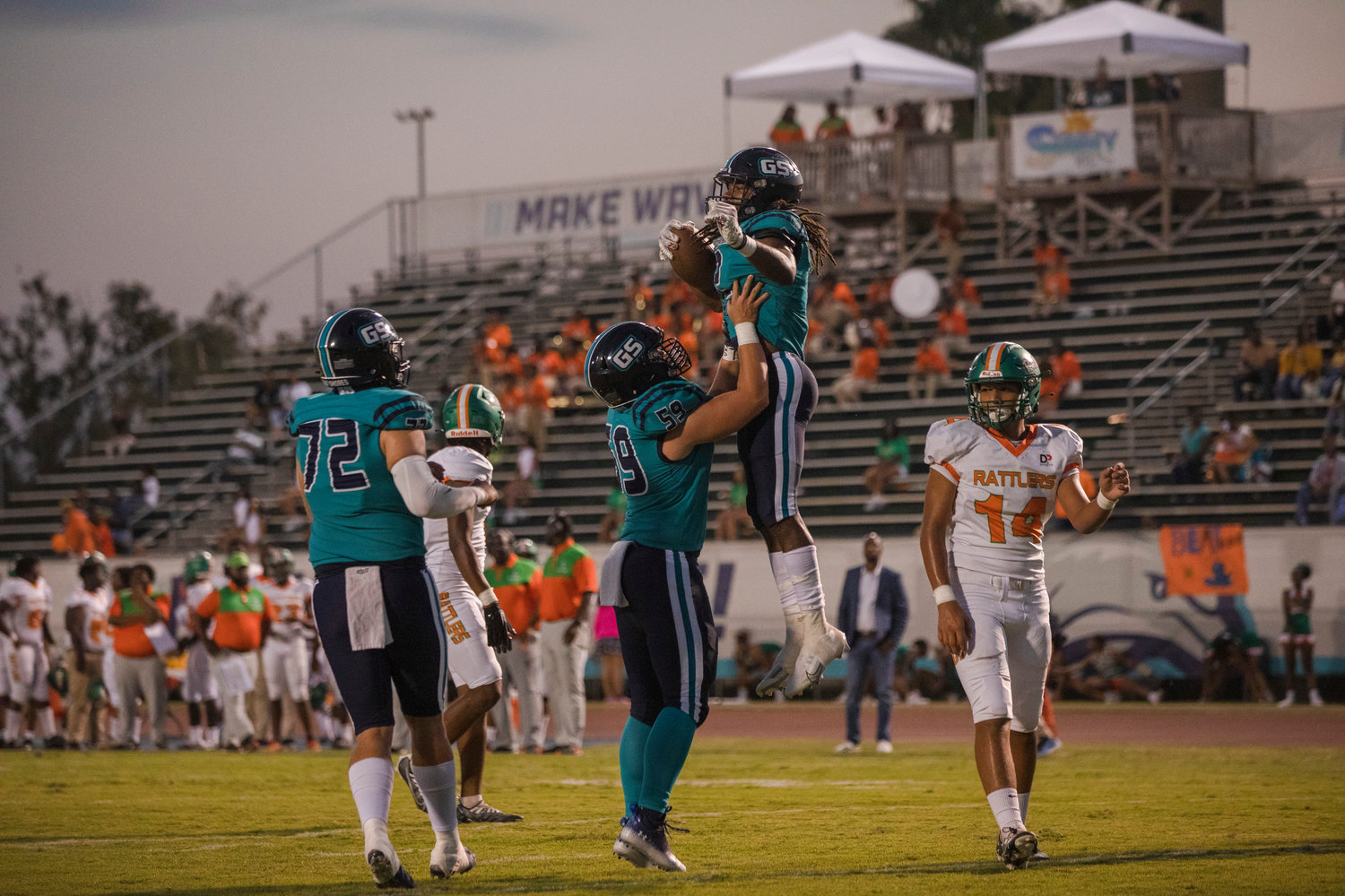 Dolphin running back Ronnie Royal (2) celebrates one of his three touchdowns against LeFlore with center Coley Smith (59) and Tyler Schepker (72) at Mickey Miller Blackwell Stadium in Gulf Shores Friday, Sept. 16.