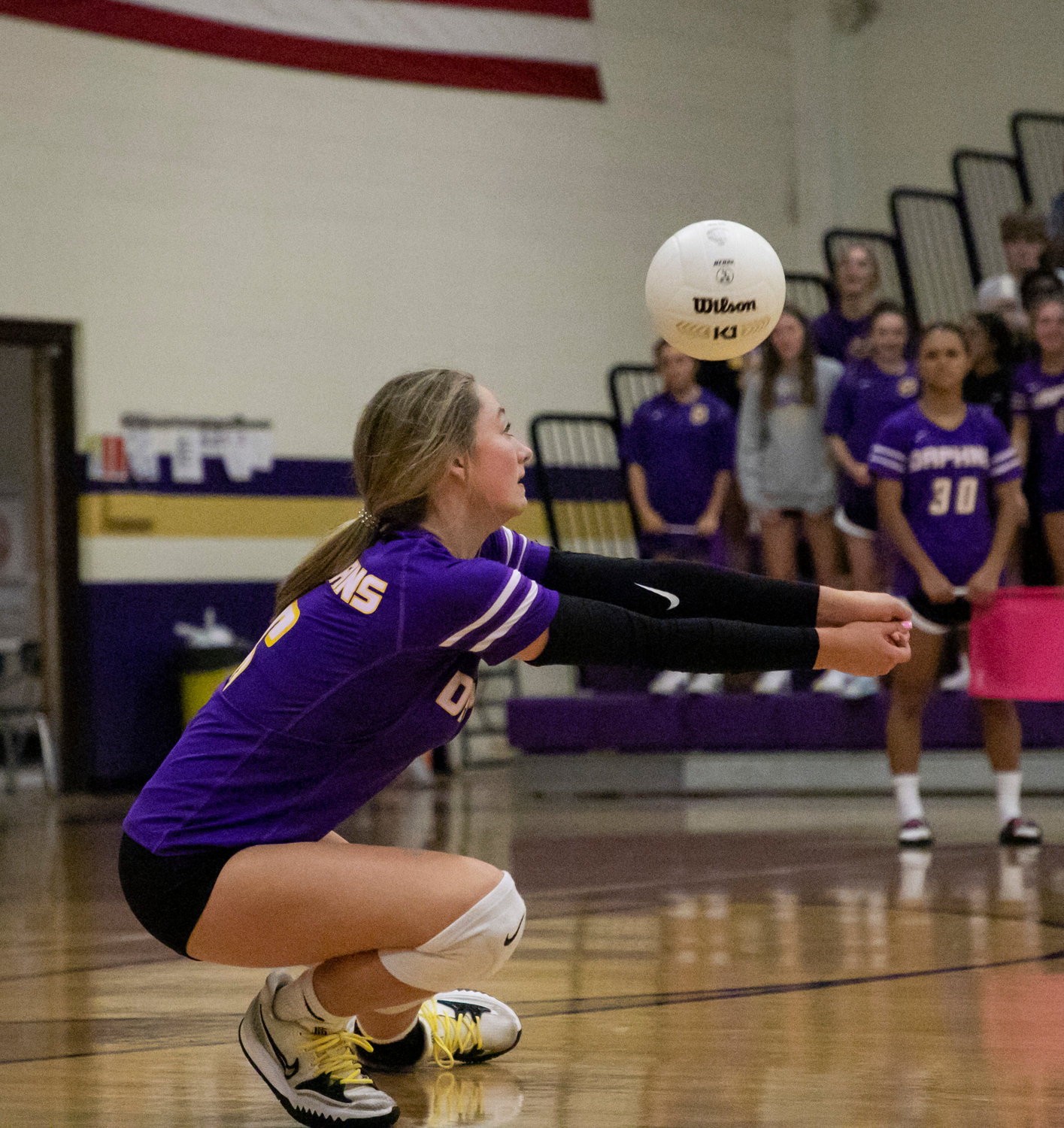 Trojan freshman outside hitter Ella Lomax dives to receive a serve in the third set of Daphne’s area match Tuesday night against McGill-Toolen at home.