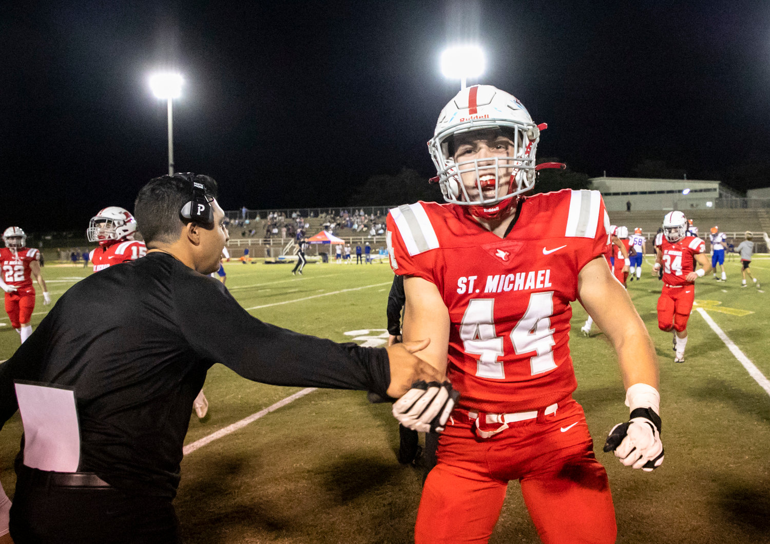 Cardinal senior Crane Guilian and the St. Michael defense celebrate a fumble recovery in the first half of the Class 4A Region 1 game against Orange Beach Thursday night at Fairhope Municipal Stadium.