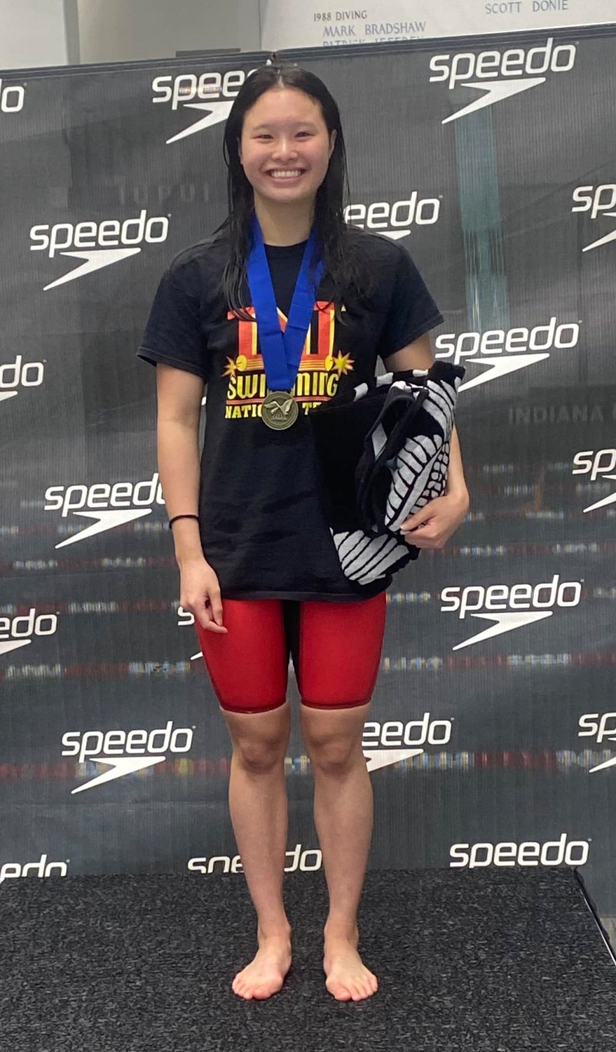 Spanish Fort junior and TNT Swimming’s Levenia Sim poses with one of her three gold medals from the NCSA Summer Junior National Championships. Sim was recently named to her second USA Swimming National Junior Team.