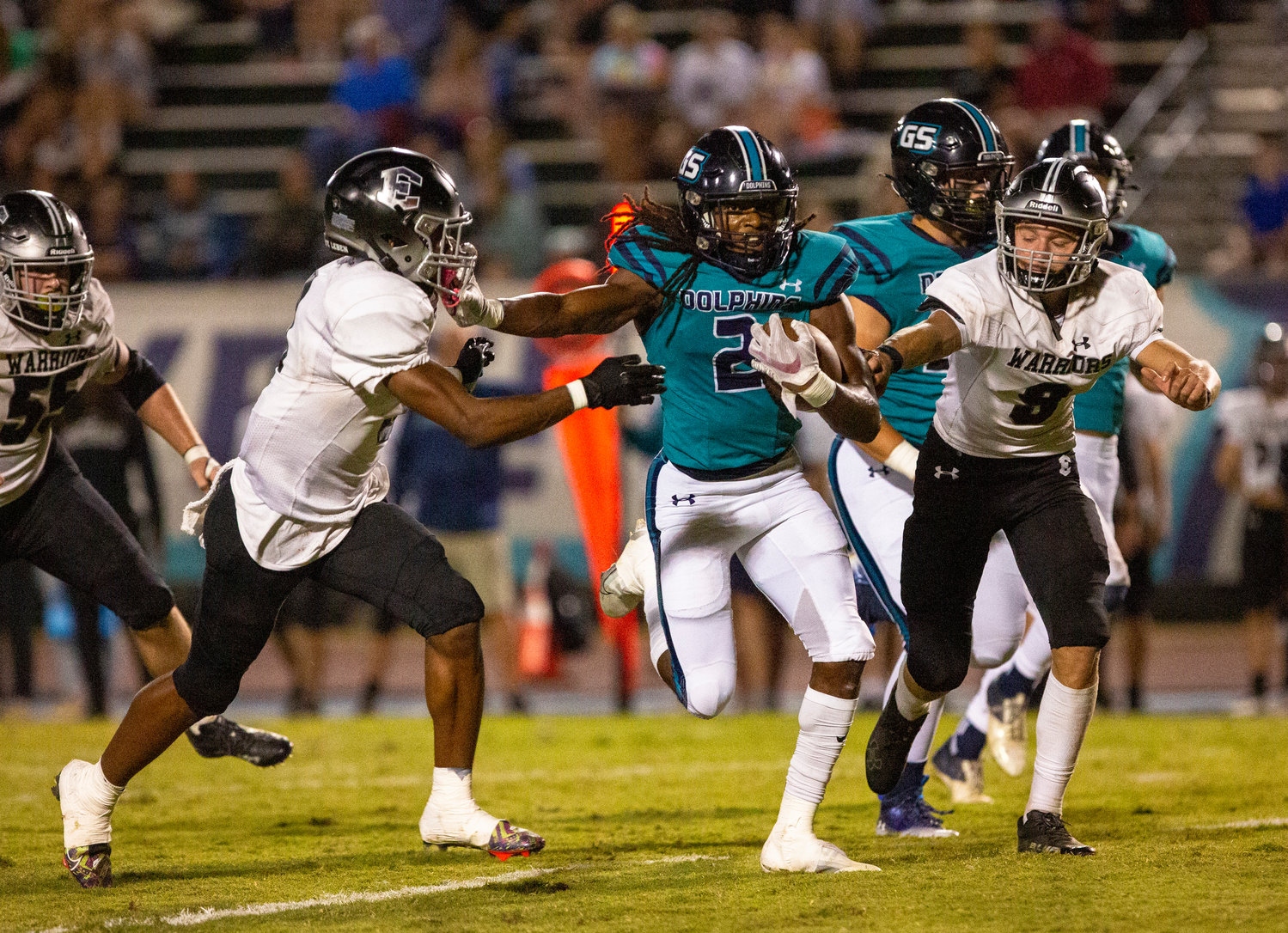 Dolphin junior Ronnie Royal stiff arms a defender while maintaining his balance to fight for extra yards on a run against the Elberta Warriors Thursday night at home. The 49-3 win qualified Gulf Shores for a playoff berth.
