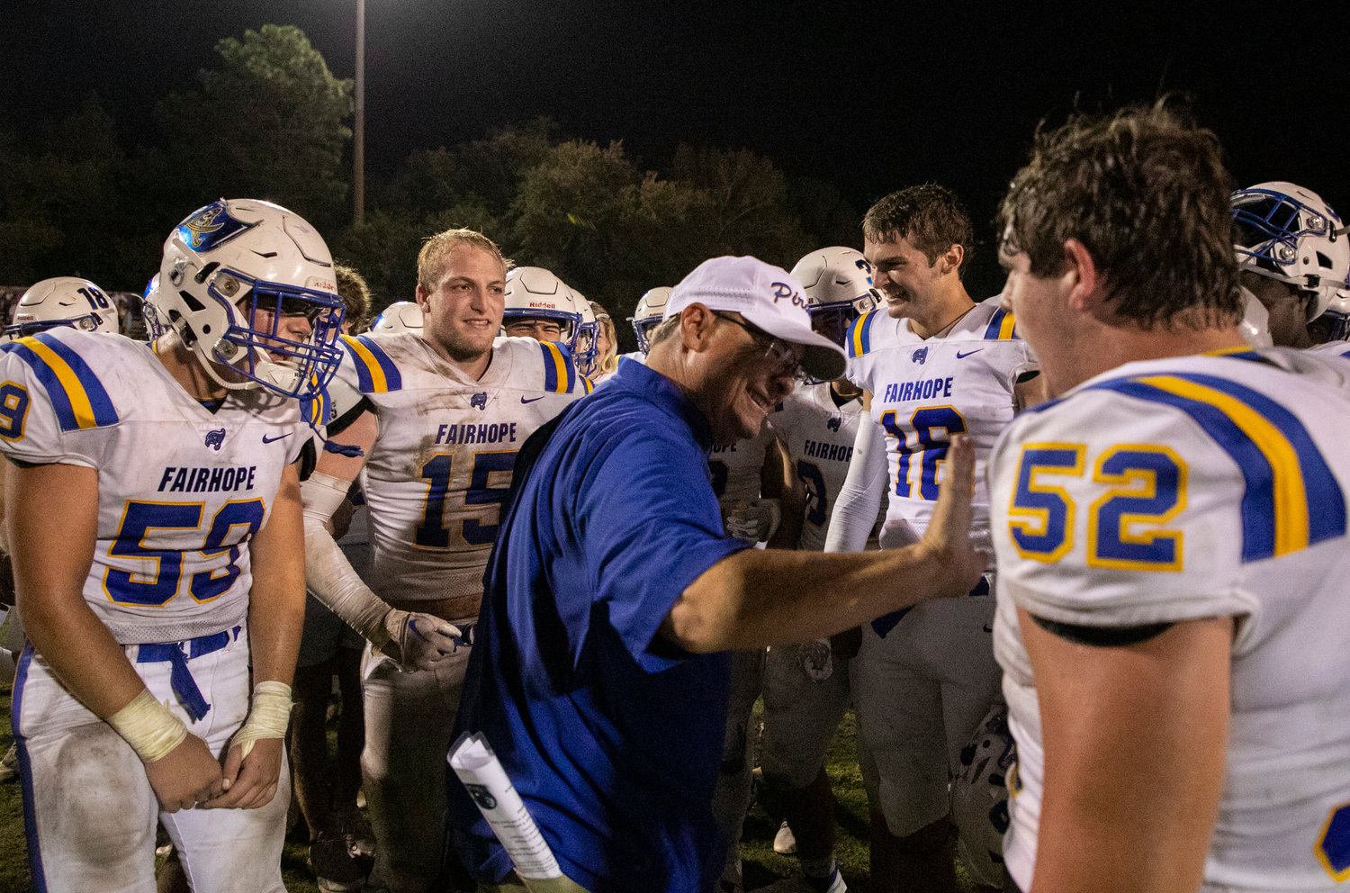 The Fairhope Pirates celebrate with head coach Tim Carter who collected his 150th career head coaching victory with the 26-7 decision over Daphne Friday night at Jubilee Stadium.