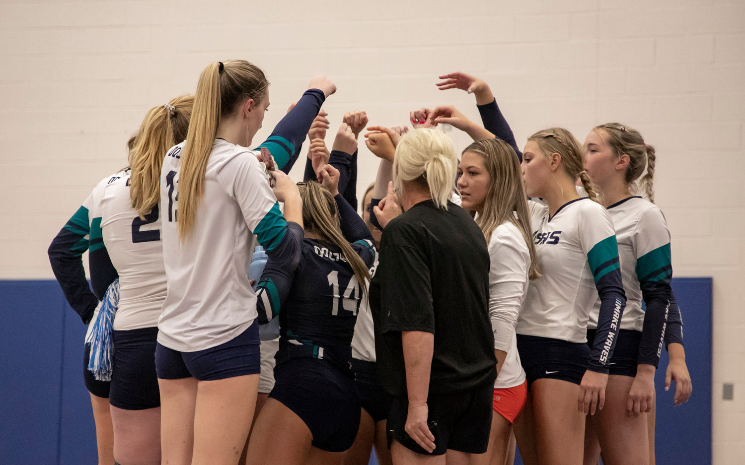 The Gulf Shores Dolphins meet during a timeout in tri-match action against the Orange Beach Makos Aug. 25. Gulf Shores opened the South Super Regional bracket this morning against Demopolis as the Class 5A Area 1 champion.