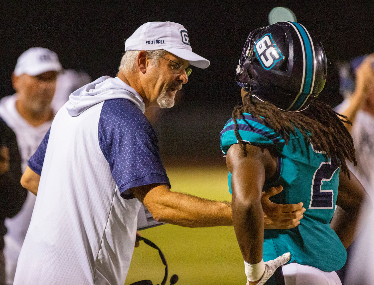 Gulf Shores defensive coordinator Paul Rhoads converses with junior Ronnie Royal after a play during the Dolphins’ Class 5A Region 1 contest against the Elberta Warriors at home Oct. 6. Gulf Shores can improve upon its best start in program history with a road win over Vigor this week.