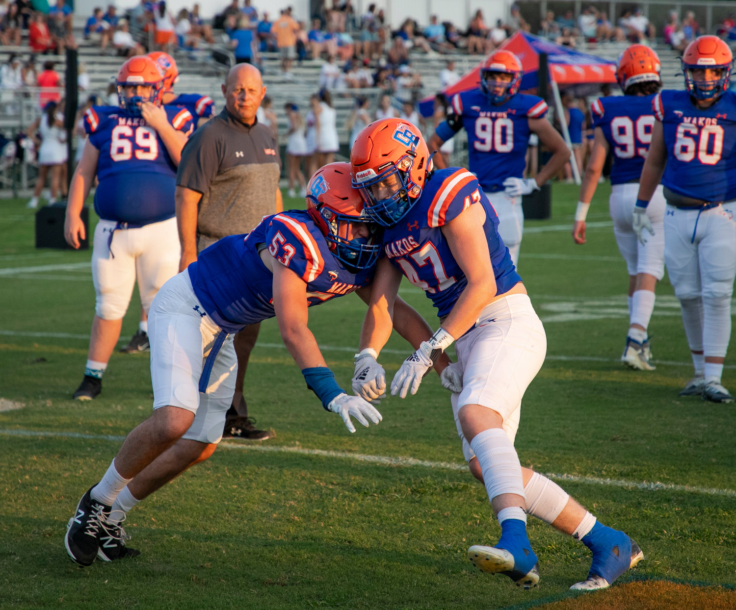 Logan Kruse (53), John Walker Colley (47) and the Orange Beach Makos warm up for their Class 4A Region 1 game against the T.R. Miller Tigers at home Sept. 16. Orange Beach will return to the Sportsplex this Friday to host its second consecutive first-round playoff game against B.T. Washington.