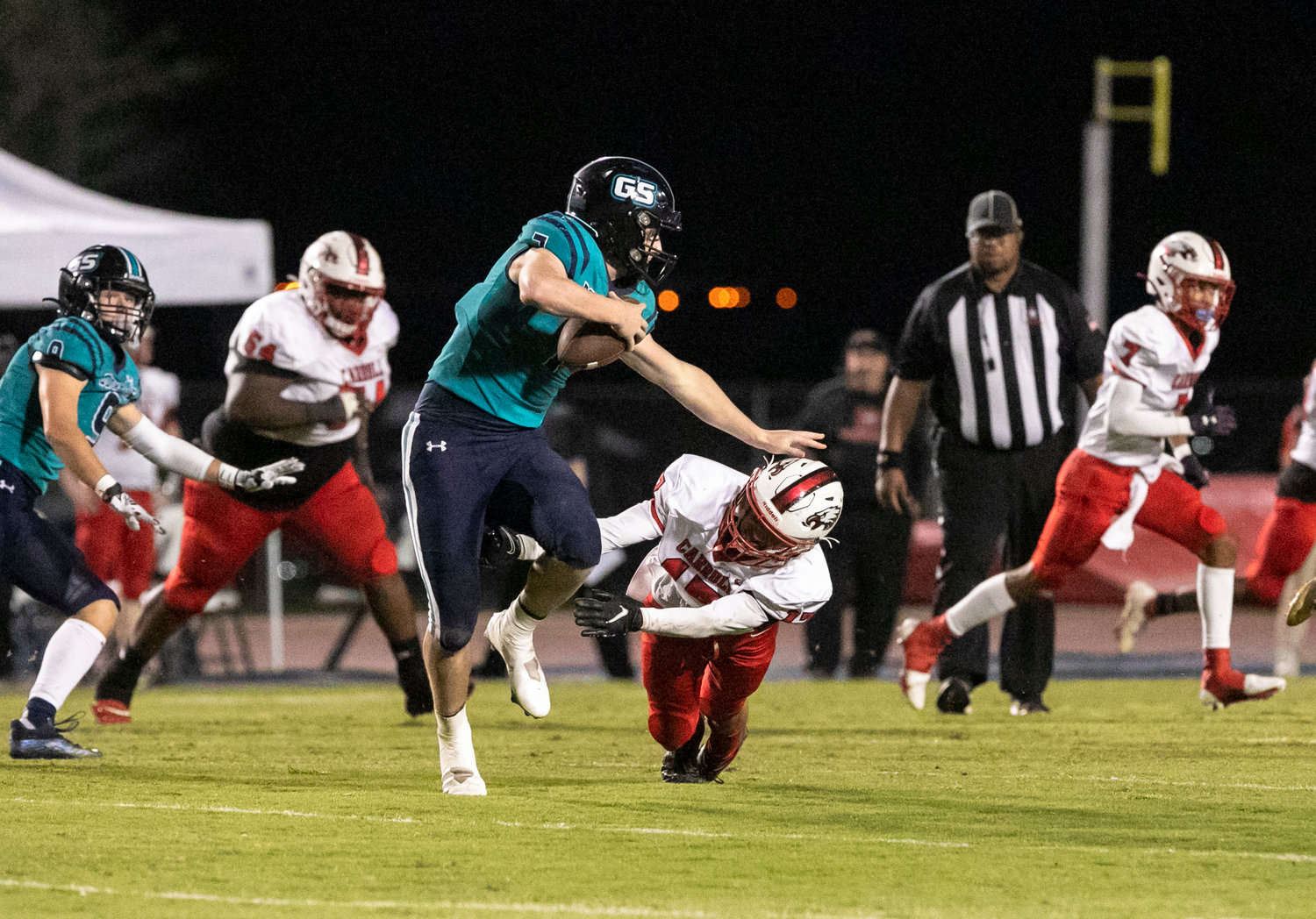 Gulf Shores quarterback Brendon Byrd delivers a stiff arm to a Carroll Eagle defender on a second-quarter scramble during the Dolphins’ first-round playoff game at home Friday night. Byrd ran for a touchdown and threw two touchdowns to help Gulf Shores win its first-ever home playoff game 42-0.