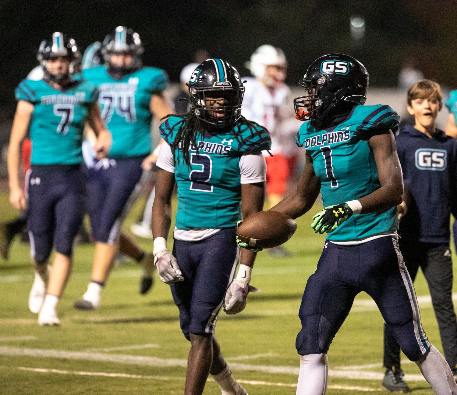 Ronnie Royal (2) celebrates with Braden Jackson (1) after the pair connected on a passing touchdown in the second quarter of the Dolphins’ first-round playoff game against Carroll Friday, Nov. 4, at the Gulf Shores Sportsplex.
