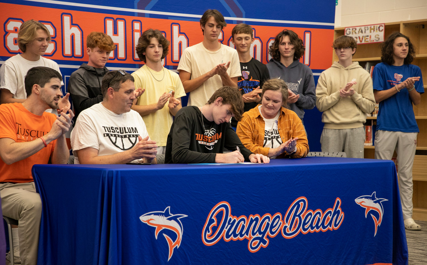 Mako senior Joey Robertson puts pen to paper to ink the commitment he made to the University of Tusculum basketball program Sept. 10 during Monday afternoon’s signing ceremony at Orange Beach High School. Robertson, the first Mako basketball player named all-state, became the first from Orange Beach to sign with a college basketball team.