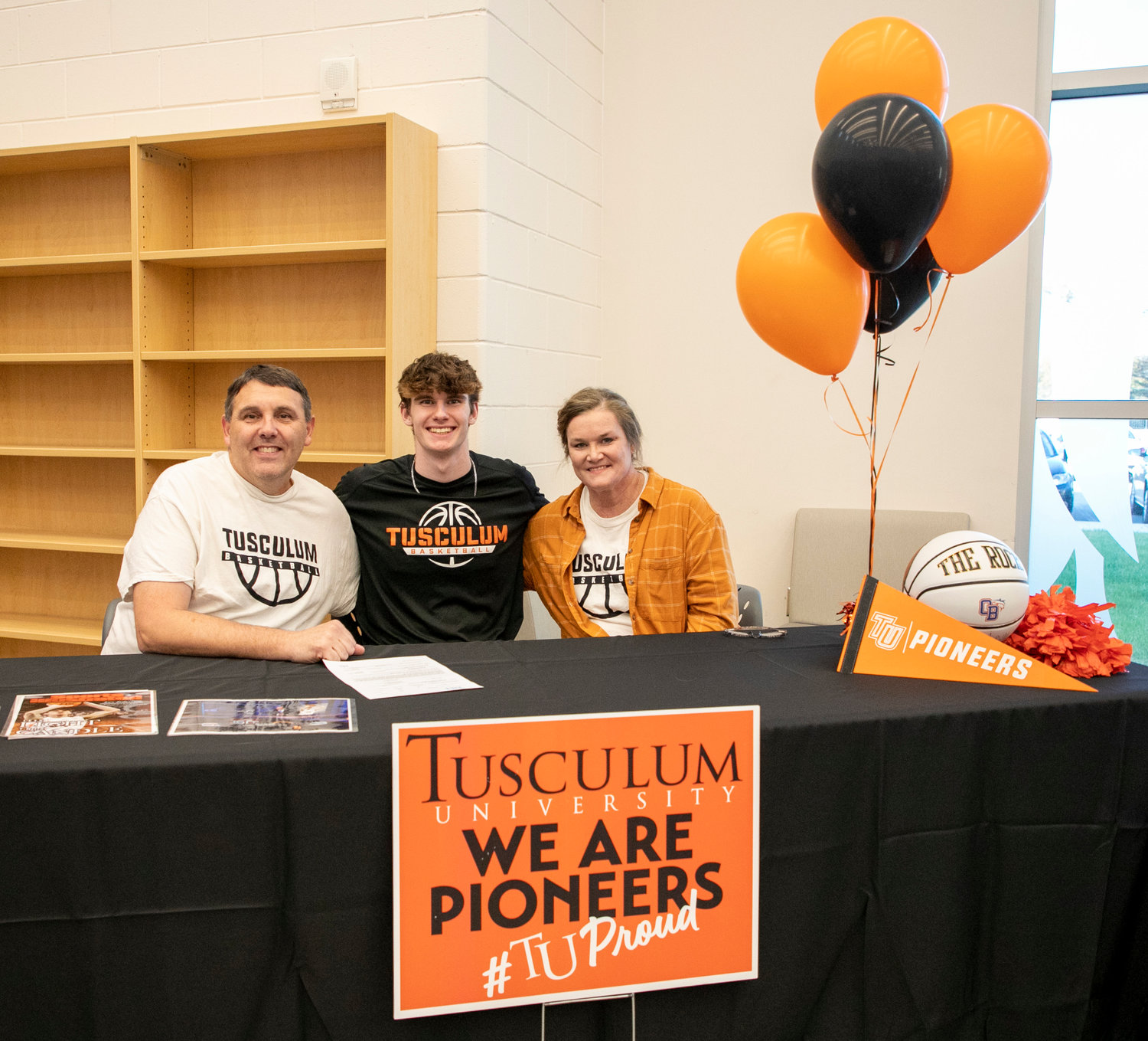Joey Robertson poses with his parents after he signed with the Tusculum basketball program Monday, Nov. 14, at Orange Beach High School as part of the first wave of National Signing Day.