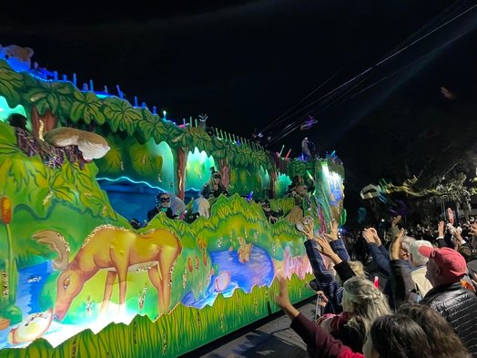 Beads fly off a float during Daphne's 2022 Mardi Gras parade.