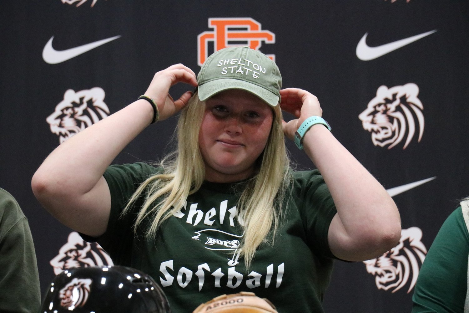 Aspen Gerald dons the cap of her new softball team, the Shelton State Buccaneers, during a Nov. 18 signing ceremony at Baldwin County High School. Before then, Gerald will look to lead the Lady Tigers to a second straight state tournament this upcoming spring.