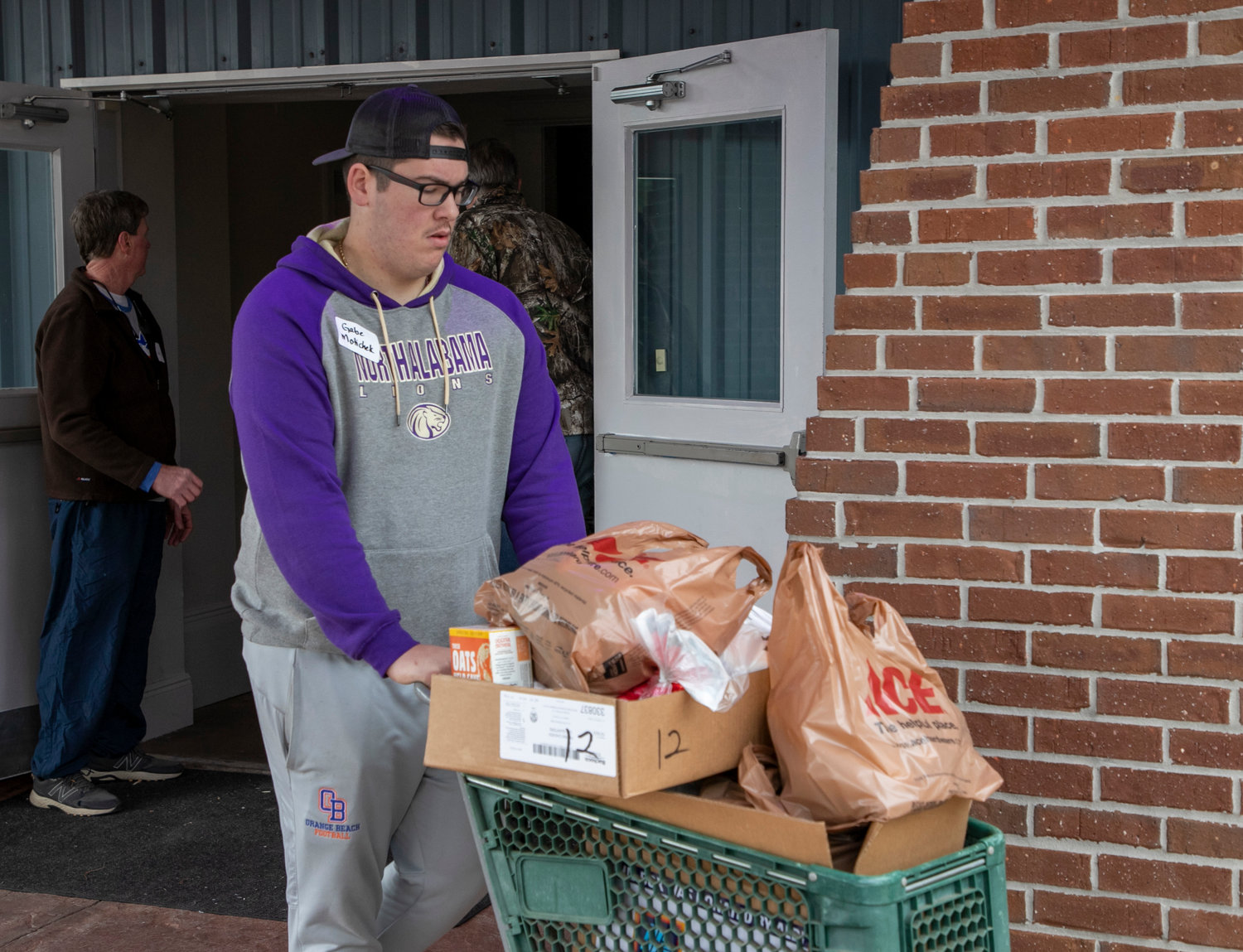 Orange Beach senior Gabe Moticheck wheels a basket of items that included the ingredients to make a Thanksgiving dinner during The Island Church’s food distribution Saturday morning, Nov. 19. It was the ninth straight year the church distributed food around Thanksgiving and they saw their largest turnout yet with 222 families signed up.