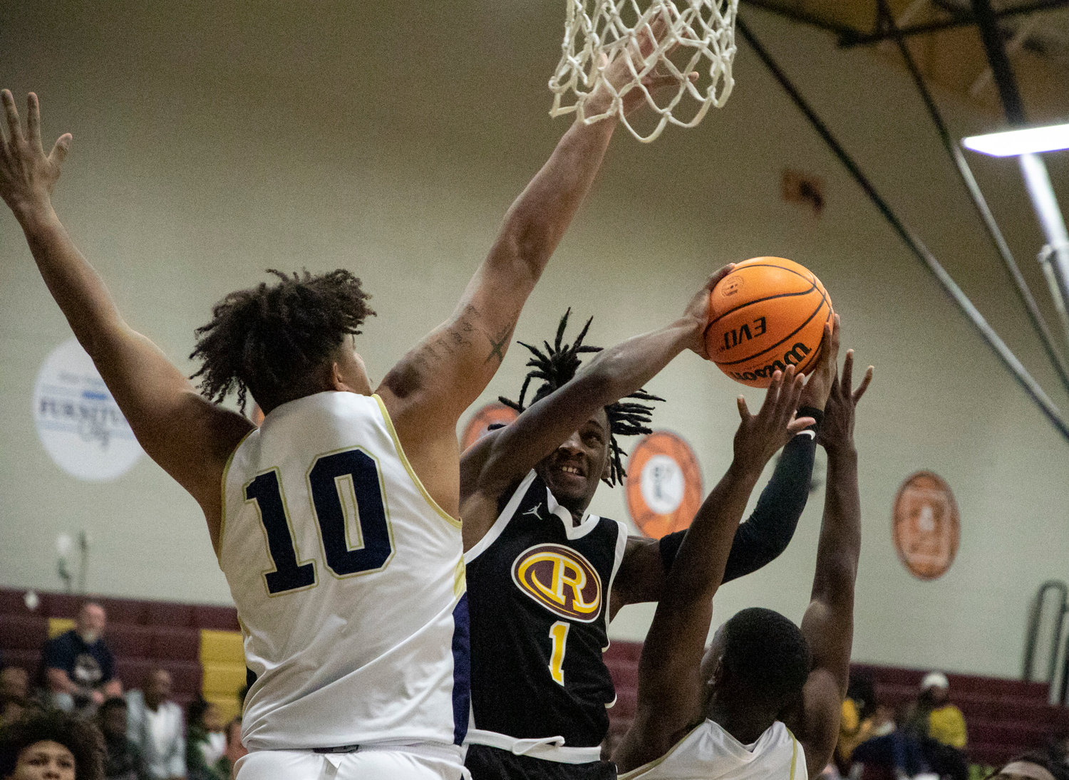 Robertsdale senior Glen Williams (1) attacks the rim with defense from Foley senior Cam Schultz (10) during the opening-round matchup between the Golden Bears and Lions at the Pre-Thanksgiving Tournament at Robertsdale High School Saturday, Nov. 19.