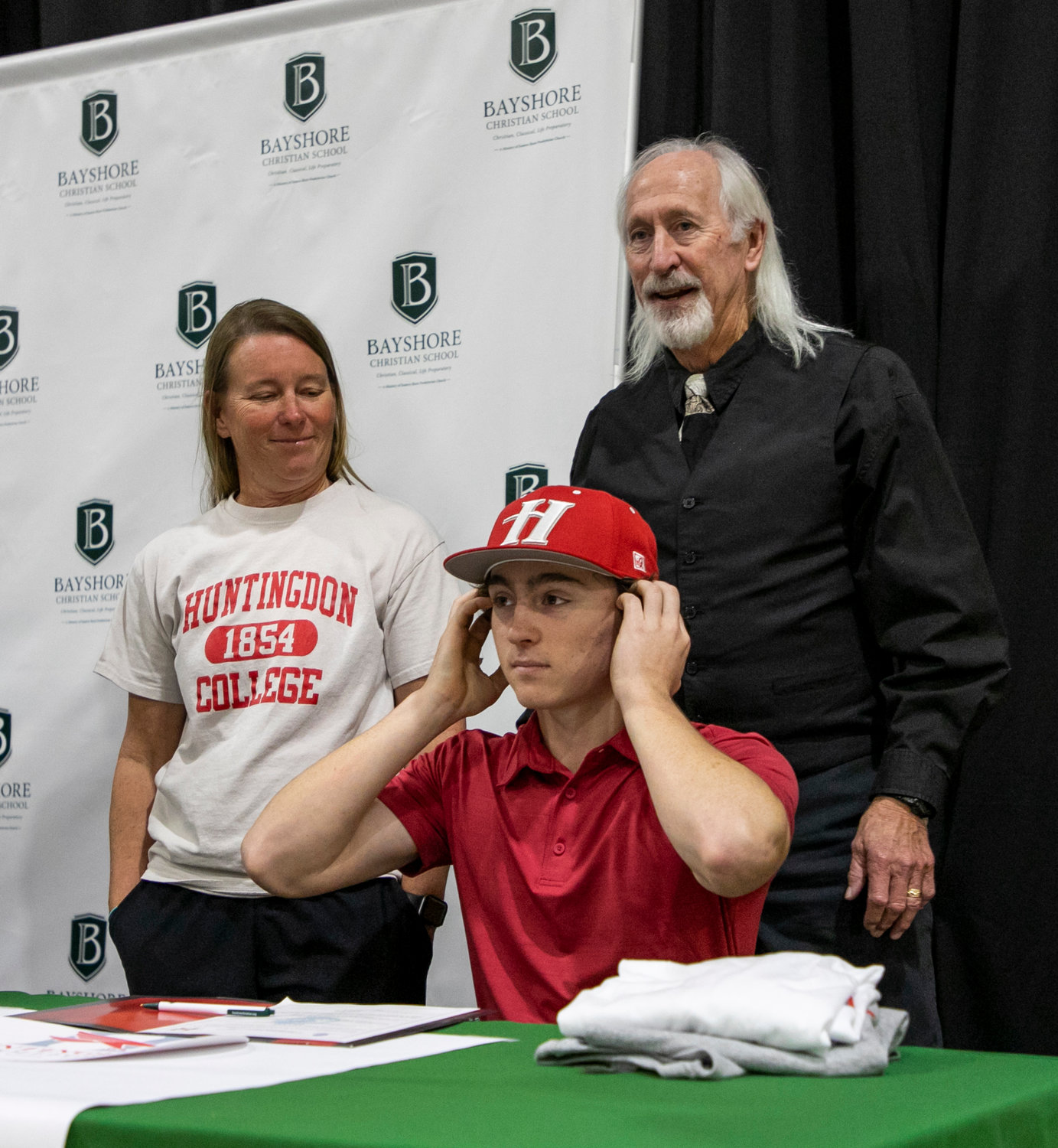 Mikael Bryant adjusts his new cap during Wednesday’s signing ceremony after he signed his National Letter of Intent to join the Huntingdon Hawks baseball squad after his senior season with the Bayshore Christian Eagles.